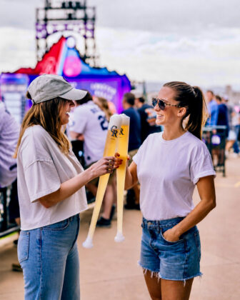 Women cheers "beer bat" drinks at Coors Field.