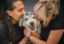 Fetch Photo Truck Turns a Trailer Into a Dog Portrait Studio Two people kiss their dog in a photo by Fetch Photo Truck.