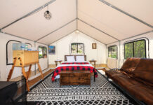 The Best Colorado Glamping Spots Near National Parks Interior of glamping tent with large bed at Arapaho Valley Ranch.
