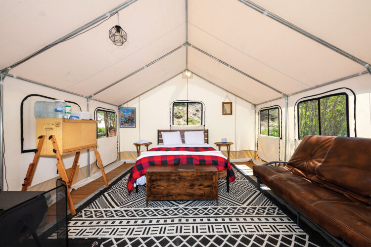 Interior of glamping tent with large bed at Arapaho Valley Ranch.