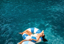 A Summer Issue Made for Backyard Living Women lounge in inner tubes in a backyard pool.
