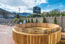 The Outrider Hotel Proves Manitou Springs Is More than a Pit Stop Exterior pool area with barrel hot tub at The Outrider Hotel.