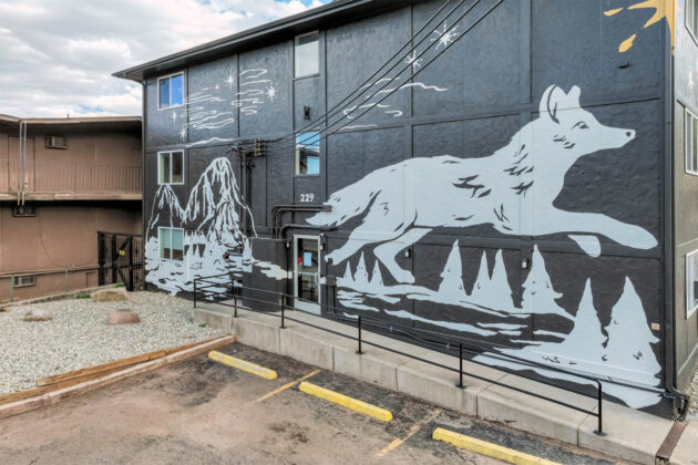 Exterior mural of wolf logo at The Outrider Hotel.