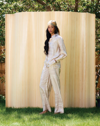 Women poses in backyard in front of bamboo fence.