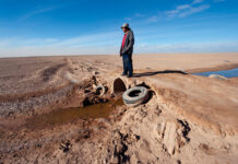 Man overlooks dried up section of the Colorado River.