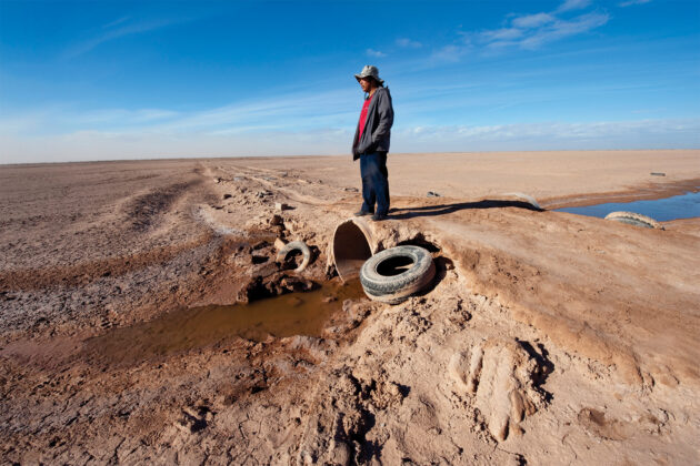 Man overlooks dried up section of the Colorado River.