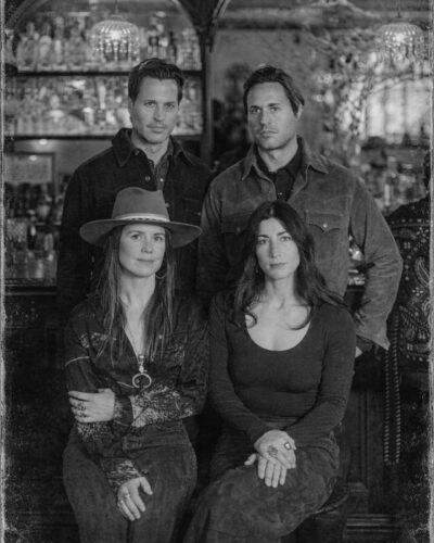 The partners of Van Atta Telluride: Mark Barboni, John Barboni, Rebecca Adams, and Macy Pryor pose in front of the bar.