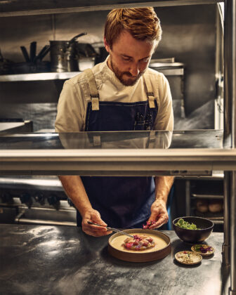 Chef put the finishing touches on his dish in the 2026 Colorado Chefs feature.