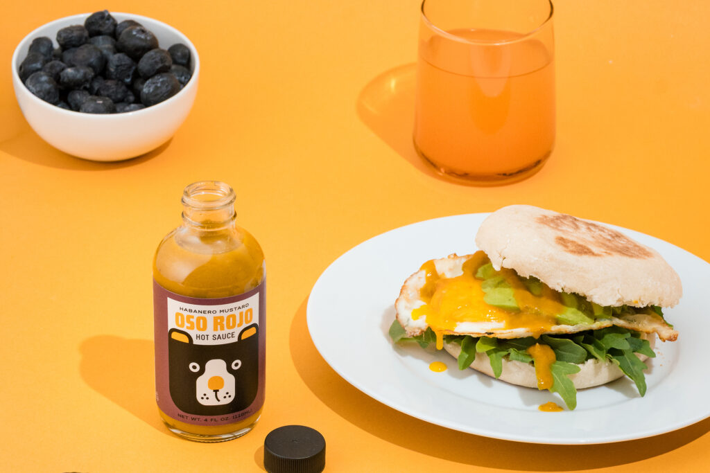 Oso Rojo Hot Sauce bottle and a breakfast sandwhich.