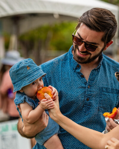 Baby eats a peach at the Palisade Peach Festival.