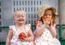 Two young girls eat peaches at the Palisade Peach Festival.