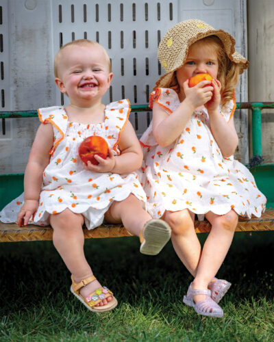Two young girls eat peaches at the Palisade Peach Festival.