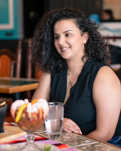 Woman sits at dining table in Aurora restaurant.