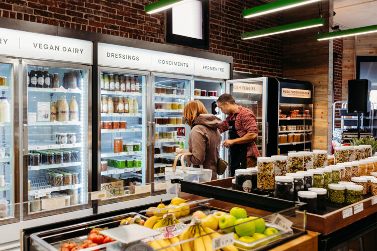 Customers shop in the freezer section at Nude Foods Market.