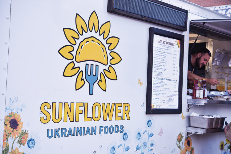 The Sunflower Ukrainian Foods food truck featuring a sunflower-and-fork logo, illustrated flowers, and a menu beside the service window.