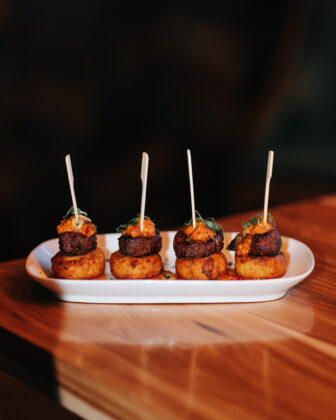 Four skewered steak bites served atop crispy potato bites and finished with a savory topping.