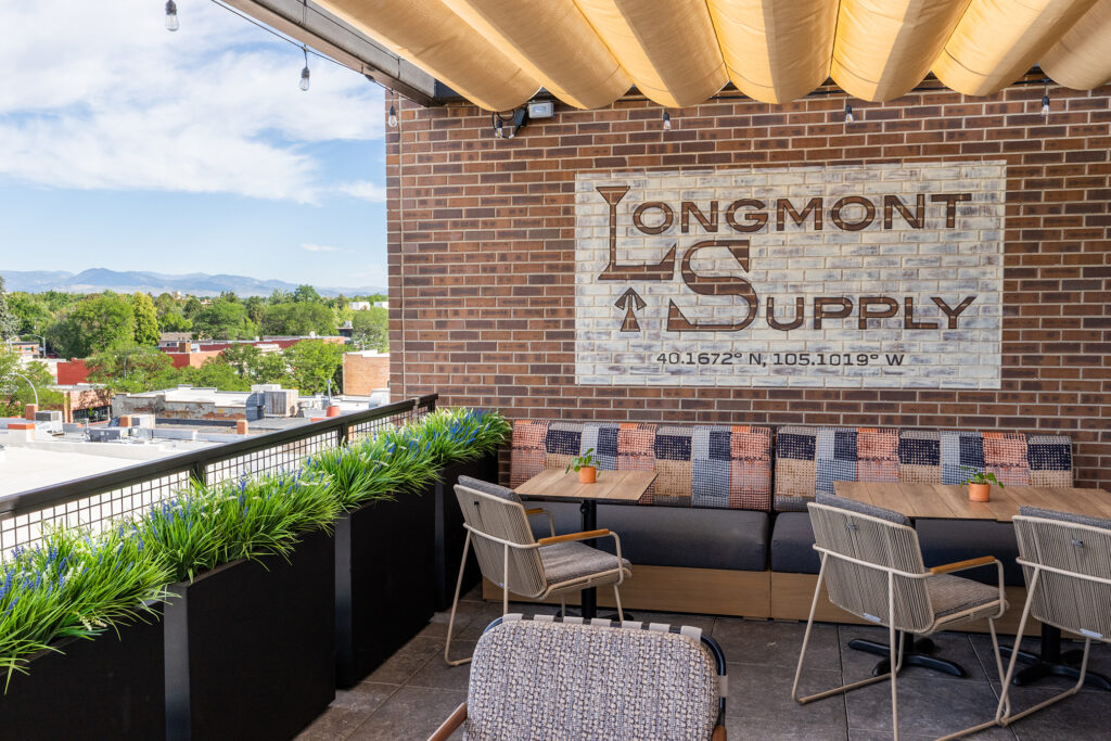 Longmont Supply rooftop patio with shaded seating and Front Range views.