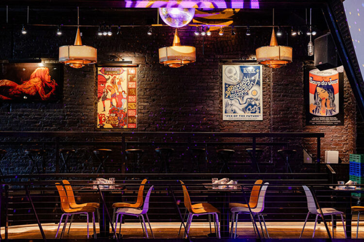 Colorful artwork, exposed brick, and balcony seating inside Ophelia’s Electric Soapbox.
