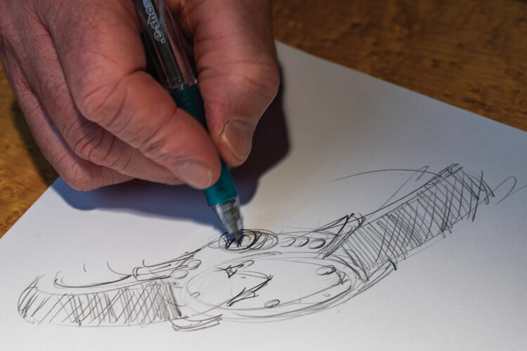 Close-up of John Atencio’s hand sketching a wristwatch design.