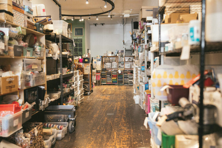 An aisle lined with bins of donated craft supplies and colorful paper at ReCreative Denver.
