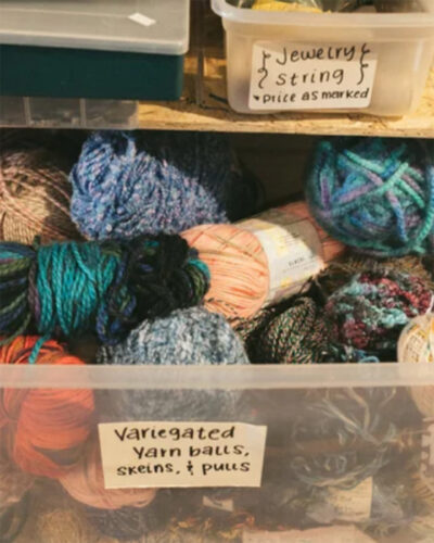Colorful yarn balls and skeins in a labeled bin at ReCreative Denver.