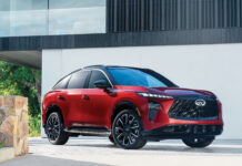 Red Infiniti QX65 with a black roof parked outside a modern home.