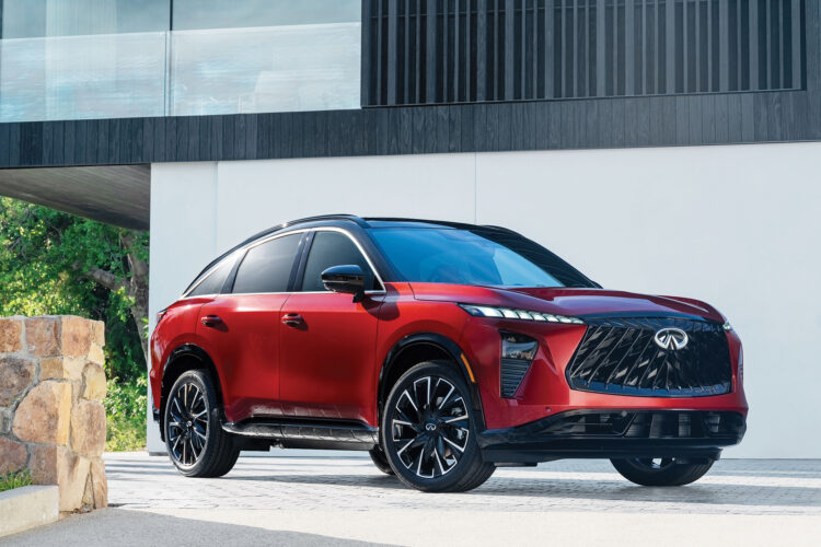 Red Infiniti QX65 with a black roof parked outside a modern home.